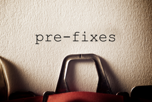 Typewriter with the hyphenated word "pre-fixes" typed on an otherwise blank sheet of paper