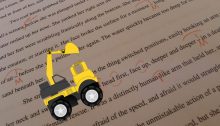 Backhoe cartoon drives across edited manuscript