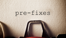 Typewriter with the hyphenated word "pre-fixes" typed on an otherwise blank sheet of paper