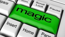 Closeup of computer keyboard with Enter key replaced by green key with the word "magic" printed on it