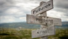 Wooden signpost featuring boards for future, present, and past